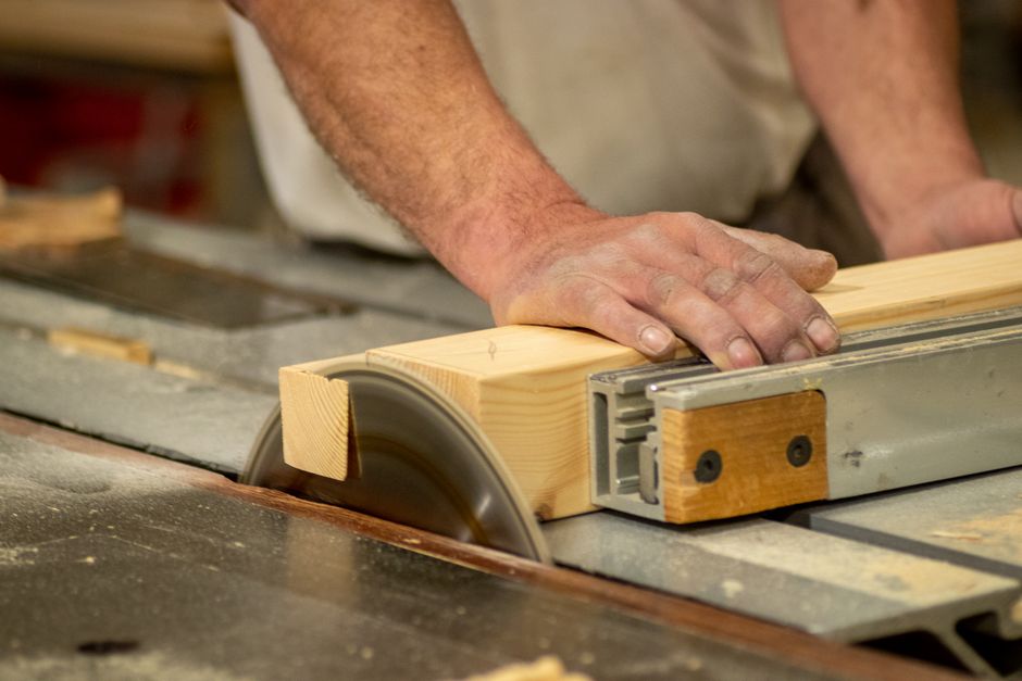 Carpenter inspecting custom kitchen cabinets in a workshop